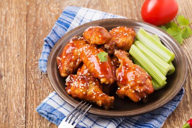 Fırında tavuk kanadı bal soslu susam serpilir.