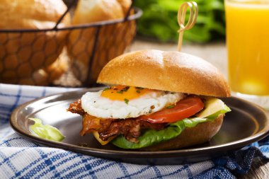 Kızarmış yumurta, pastırma, peynir ve sebzeli sandviç..