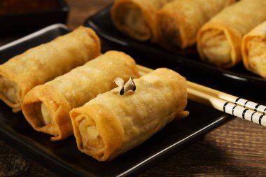 Siyah bir tabakta sebze ile pişmiş böreği