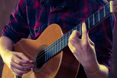 Genç adam bir konser sırasında akustik gitar çalmak. -Vintage co