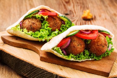 Falafel ve taze sebzeler ahşap masada pide