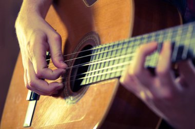 Genç adam bir konser sırasında akustik gitar çalmak. -Vintage co