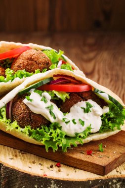 Falafel ve taze sebzeler ahşap masada pide