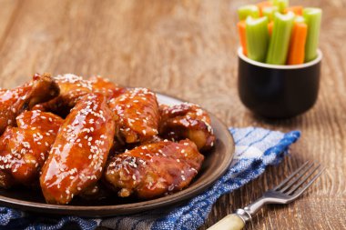 Fırında tavuk kanadı bal soslu susam serpilir.