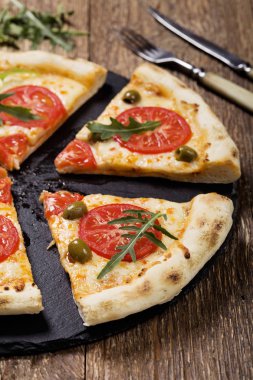Pizza Vejetaryen taş siyah plaka üzerinde deneyin ile taze domates