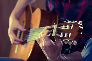 Genç adam bir konser sırasında akustik gitar çalmak. -Vintage co