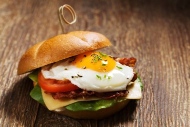 Kızarmış yumurta, pastırma, peynir ve sebzeli sandviç..