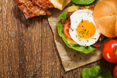 Kızarmış yumurta, pastırma, peynir ve sebzeli sandviç..