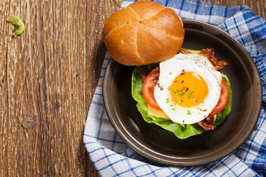 Kızarmış yumurta, pastırma, peynir ve sebzeli sandviç..