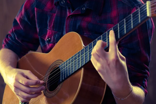Genç adam bir konser sırasında akustik gitar çalmak. -Vintage co
