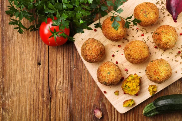 Chickpea falafel balls on a wooden desk with vegetables — Stock Photo, Image