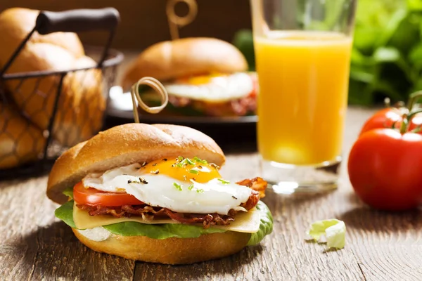 Sandwich con huevo frito, tocino, queso y verduras. —  Fotos de Stock