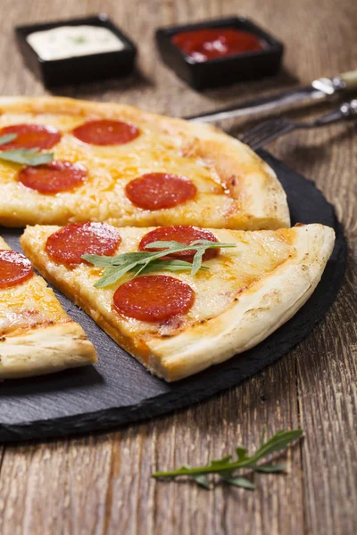 Pizza peperoni op stenen zwart proberen met rucola en mozzarella che — Stockfoto