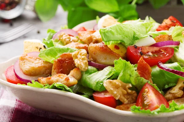 Delicious salad with chicken, nuts, egg and vegetables.