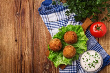 Tahta bir masada sebzeli nohut köftesi.