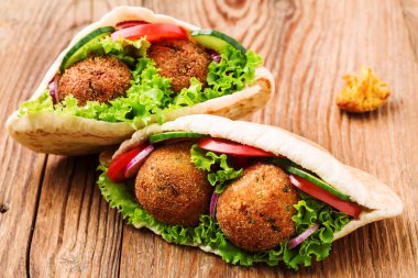 Falafel ve taze sebzeler ahşap masada pide