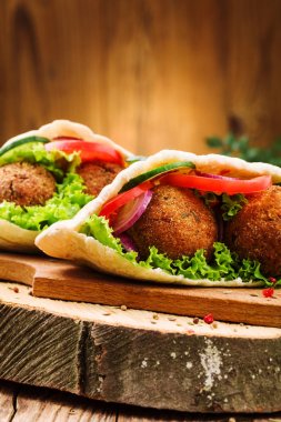 Falafel ve taze sebzeler ahşap masada pide