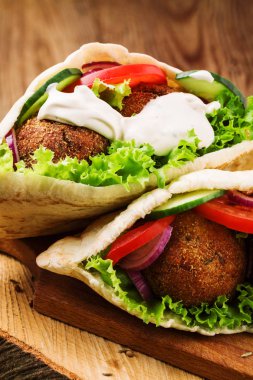 Falafel ve taze sebzeler ahşap masada pide