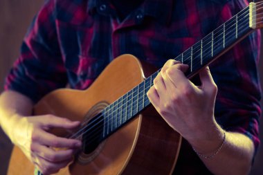 Genç adam bir konser sırasında akustik gitar çalmak. -Vintage co
