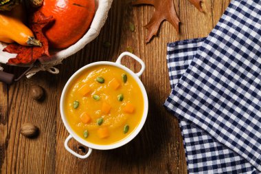 Çorba, balkabağı kreması kavrulmuş tohumlar ve kızarmış ekmeklerle servis edilir..