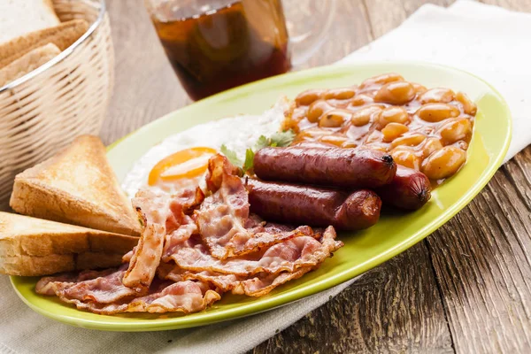 Compleet Engels ontbijt met spek, worst, gebakken ei, gebakken bea — Stockfoto