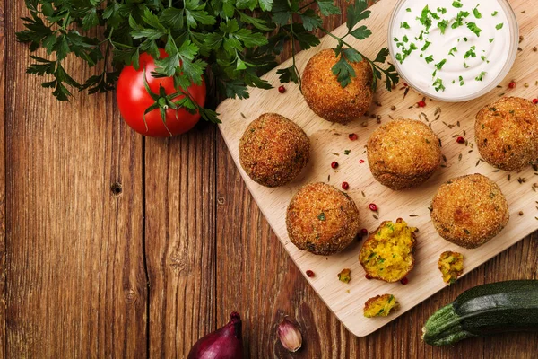 Mingi de falafel de năut pe un birou din lemn cu legume — Fotografie, imagine de stoc