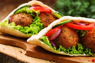 Falafel ve taze sebzeler ahşap masada pide