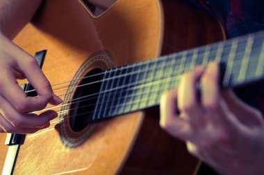 Genç adam bir konser sırasında akustik gitar çalmak. -Vintage co