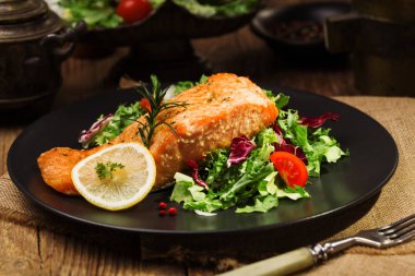 Fırında somon taze sebzelerle servis edilir..