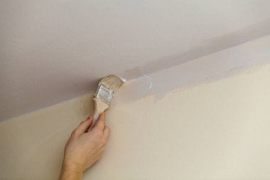 Brush weld the walls with the ceiling white paint. clipart