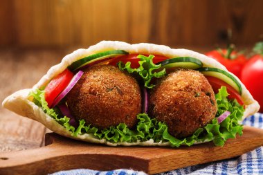 Falafel ve taze sebzeler ahşap masada pide
