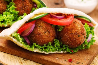 Falafel ve taze sebzeler ahşap masada pide