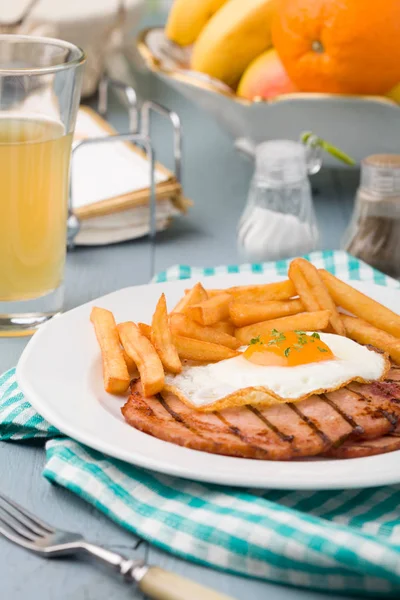 Desayuno inglés con jamón a la parrilla, huevo frito y papas fritas . —  Fotos de Stock