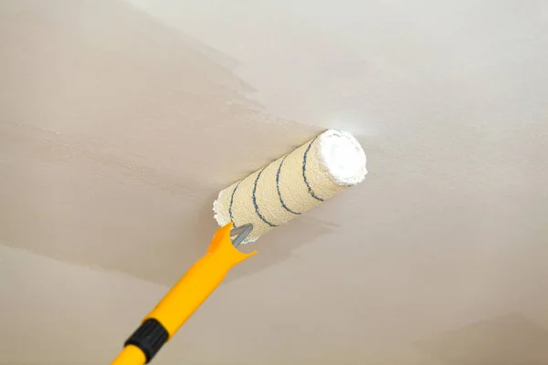 Pintura del techo un rodillo con pintura blanca . —  Fotos de Stock