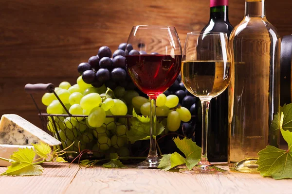 Copos de vinho tinto e branco, servidos com uvas e queijo — Fotografia de Stock