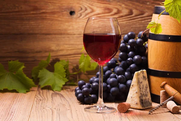 Verre de vin rouge, servi avec des raisins et du fromage — Photo