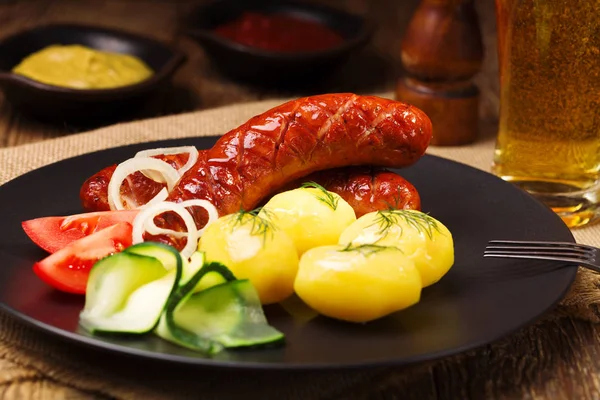 Soğan ile bir tavada ızgara sosis, haşlanmış patates ile servis — Stok fotoğraf