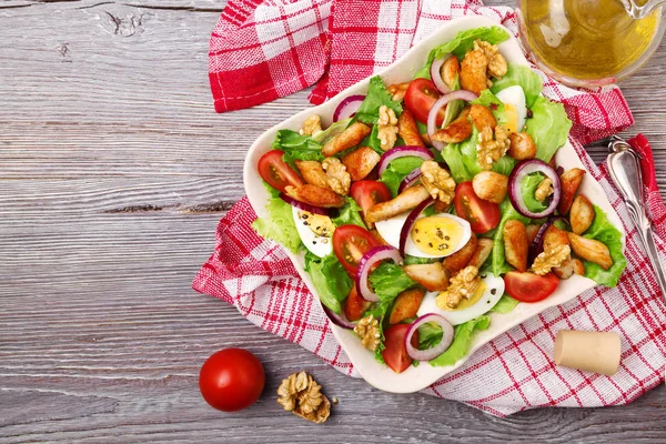 Läcker sallad med kyckling, nötter, ägg och grönsaker. — Stockfoto