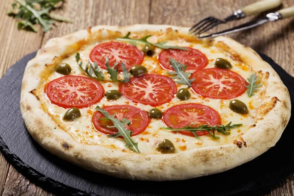 Pizza vegetariana na placa em pedra preto tente com tomates frescos — Fotografia de Stock