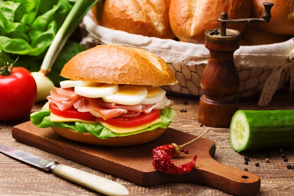 Prosciutto ham sandwich with egg and vegetables. — Stock Photo, Image