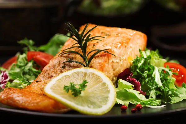 Baked salmon served with fresh vegetables. Stock Image