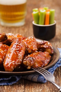 Fırında tavuk kanadı bal soslu susam serpilir.