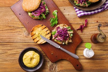 Kırmızı soğan ve marullu ördek etli hamburger..