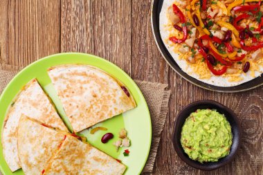 Tavuk ile Quesadilla, guacamole veya salsa sosuyla servis edilir..
