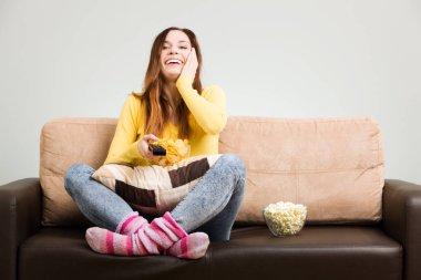 Genç kadın boş zamanlarını hom'daki kanepede televizyon izleyerek geçiriyor.