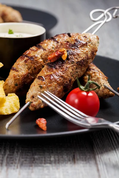 Barbecued kofta - kebeb with fries and vegetables on a plate. — Stock Photo, Image