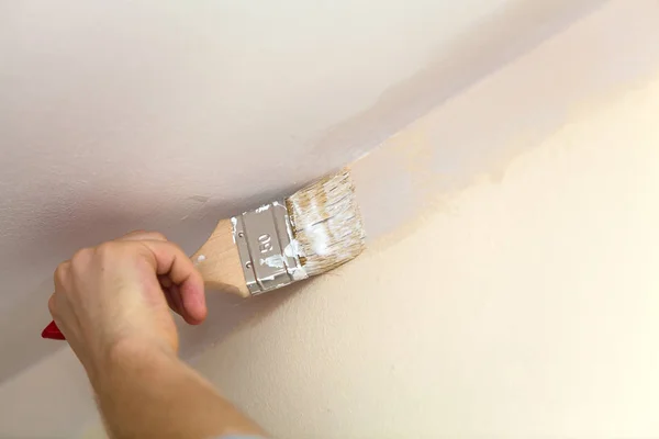 Cepillo de soldadura de las paredes con el techo de pintura blanca . — Foto de Stock