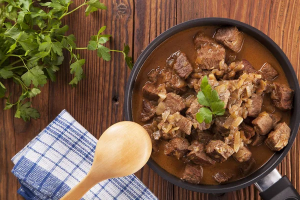 Beef stew - wooden background — Stock Photo, Image