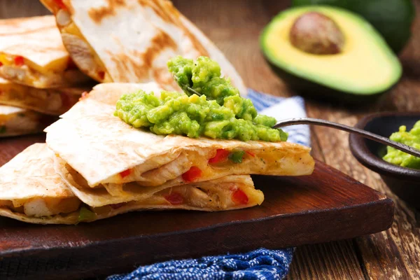 Quesadilla with chicken, served with guacamole or salsa sauce.