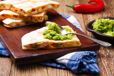 Tavuk ile Quesadilla, guacamole veya salsa sosuyla servis edilir..